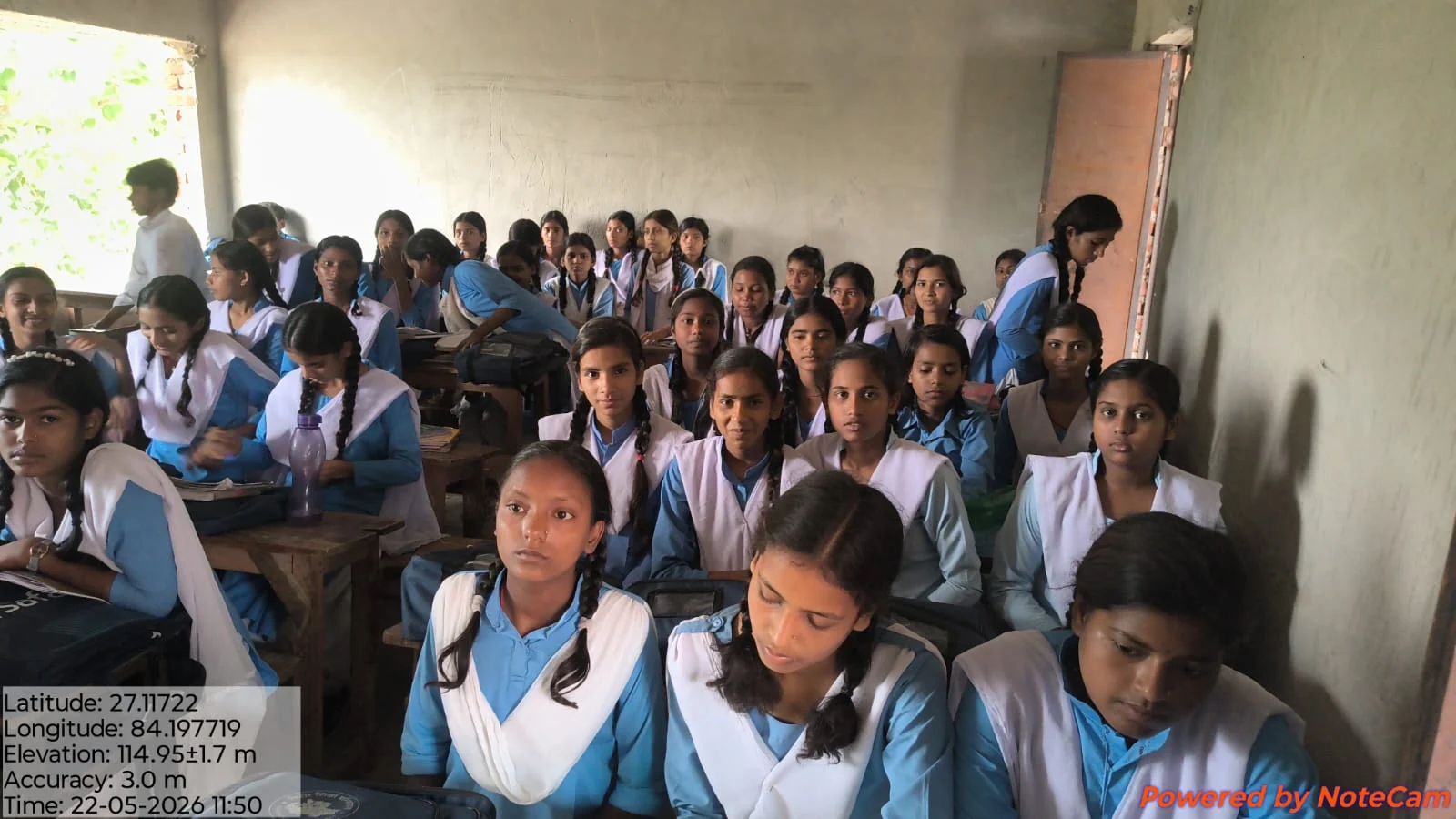 Girls in blue and white uniforms learning in their classroom