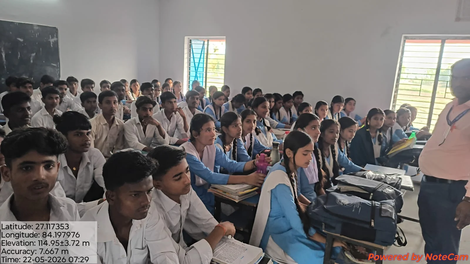 Students in blue and white uniforms learning together in a Bhaisahi classroom