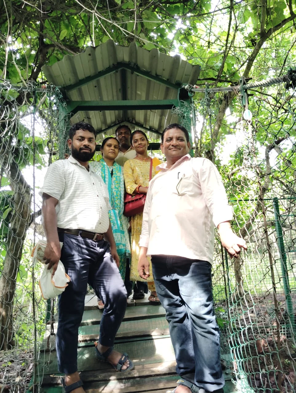 A group of teachers together on a bridge surrounded by greenery